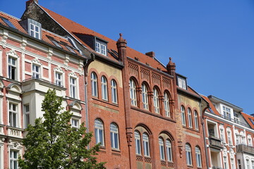 Straßenzug mit alten Häusern und der Synagoge Rykestraße in Berlin Prenzlauer Berg bei Sonnenschein und blauem Himmel