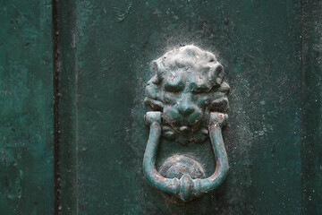 old door knocker on green wooden door