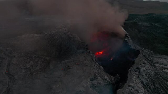 Smoking volcano crater aerial Iceland close up pan