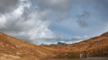 red hills, mountains and blue sky with clouds, such a beautiful autumn on the lofoten islands in polar norway