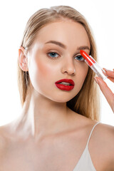 pretty young woman with red lips and blue eyes holding lipstick tube isolated on white