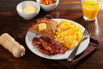 traditional scrambled egg breakfast with bacon and toast