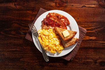 traditional scrambled egg breakfast with bacon and toast