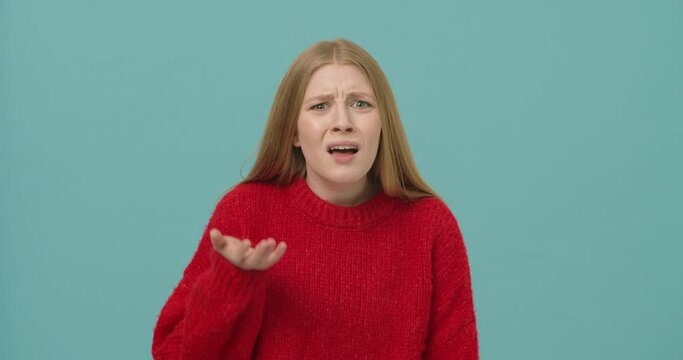Young woman with long blond hair shrugging shoulders being irritated and disappointed