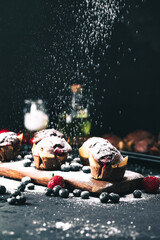 Muffin. Chocolate muffins with stawberry. Muffins on wooden stand with powder sugar. - obrazy, fototapety, plakaty