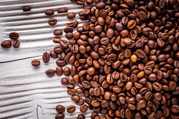 aromatic fresh coffee beans on a white wooden rustic background