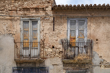 Fototapeta na wymiar facade of old abandoned italian buildng with balcony