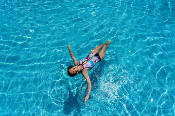 Young woman lies on a water surface in the crystal pool