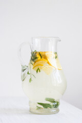Pitcher of lemonade on the white table.