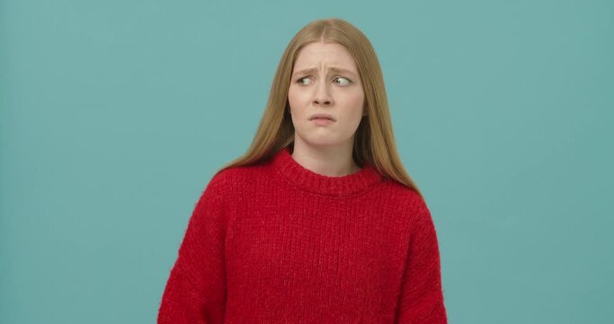 Young woman with long blond hair moving backwards expressing emotion of disgust