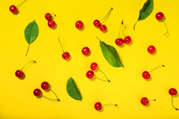 Summer pattern of ripe cherries on a yellow bright background. The minimum okznept of summer.