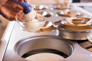 Ball of vanilla ice cream in ice cream razor in cafe