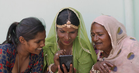 Group of indian females talking via smartphone outdoors