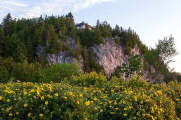 Small house on top of a steep cliff seen during a summer dawn, Murray Bay, Quebec, Canada