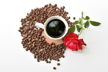 Coffee, rose and coffee beans on a white background, top view