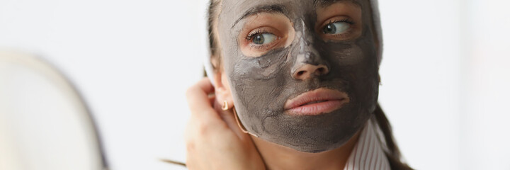 Young woman makes rejuvenating clay face mask