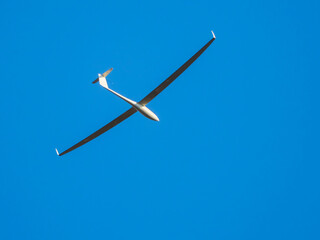 Glider flying in clear blue sky