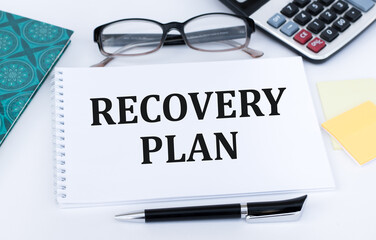 Recovery plan inscription, calculator, pen and notebook on office desk. Business concept.