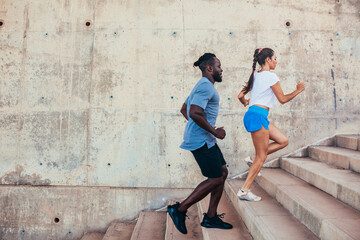 Two athletes running on stairs at urban city.