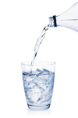 Water pouring from bottle into glass with ice cubes isolated on white background. Glass of cool water with ice.