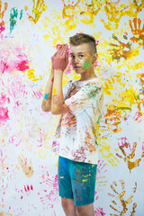 Portrait of a cute happy boy painting and having fun