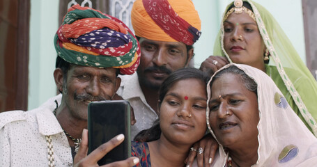 Group of South Asian people in traditional Indian clothing taking a selfie together