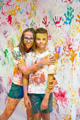 Portrait of a cute happy woman with her son painting and having fun