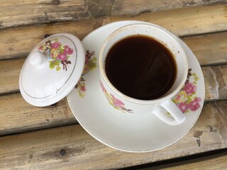 A cup of coffee with a classic cup on a table made of bamboo