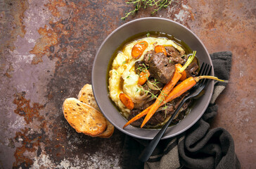 Beef bourguignon served in a rustic manner with smashed potatoes