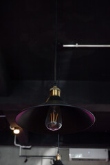 Classic lamp that is hung against the background of the roof of the room. Modern interior design for cafe
