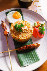 Close up fried rice. Indonesian style fried rice, egg, chicken satay, pickles and shrimp crackers