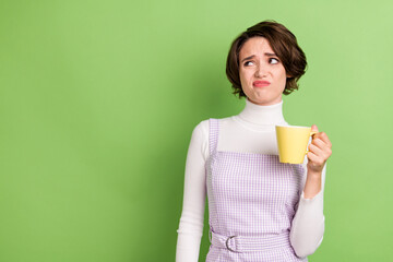 Photo portrait woman upset keeping cup with tea looking copyspace isolated pastel green color...