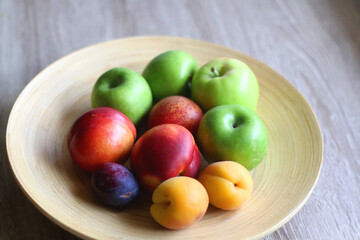 Wooden bowl with various colorful fruit. Selective focus.