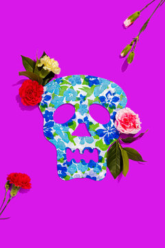 Studio shot of blooming roses and blue skull mask decorated with floral pattern