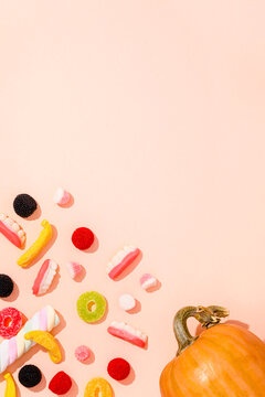 Background of various Halloween candies and single pumpkin