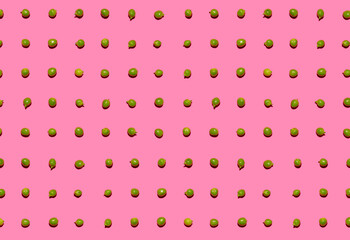 Pattern of green peas flat laid against pink background