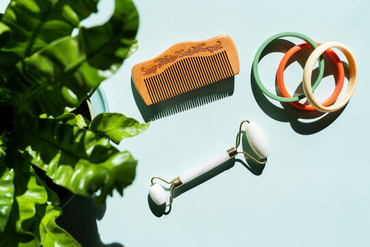 Studio shot of marble jade roller, wooden comb and colorful bracelets