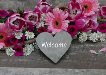 Plakat Heart with the writing welcom in front of a bouquet of flowers