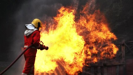 Burning Car, Side view of fireman water spray by high pressure nozzle in fire fighting operation  Fire and Firefighter training school.