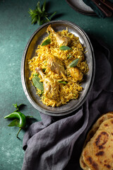 Chiken biryani Rice with yogur and mint on metal, top view. Pakistani and indian dish