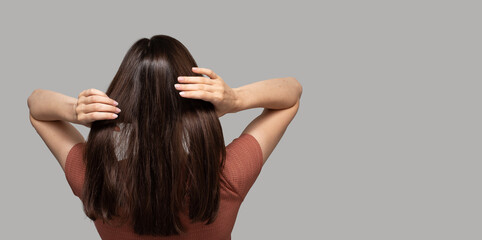 Banner with turned back girl touching her hair on light background