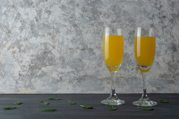 Dos copas de mimosas con champagne y jugo de naranja con hojas de menta