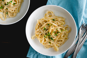Bowls of Fettuccine Alfredo Pasta: Bowls of noodles in a creamy parmesan cheese sauce