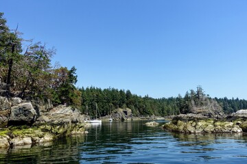 The view of an opening or entrance to a beautiful cove with boats anchored.  This is Smugglers Cove, Sunshine Coast, British Columbia, Canada