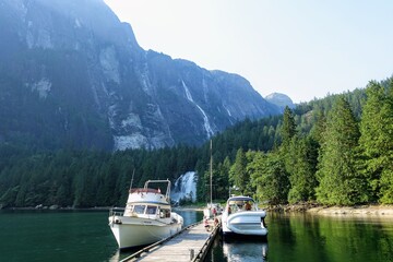 An incredible view of princess louisa inlet and chatterbox falls from the dock with boats tied up,...
