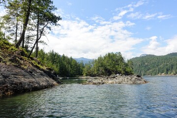The beautiful rocky shores of the Harmony Islands, with tall trees and beautiful calm waters, outside hotham sound, jervis inlet, British Columbia, Canada