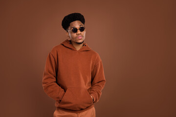 Photo of serious brunet hairdo young guy look empty space dress spectacles sportswear isolated on brown color background