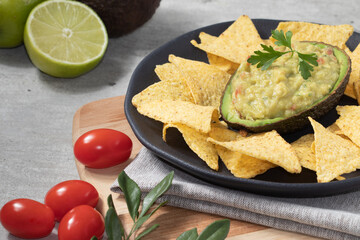 Mexican food guacamole in avocado shell served with nacho.