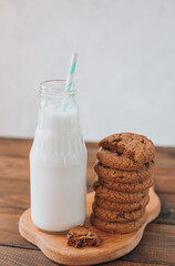 the milk poured into a bottle is on the table next to a stack of cookies. breakfast of milk and cookies