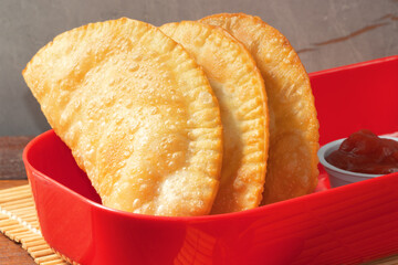 Typical Brazilian snack pastel in red bowl.